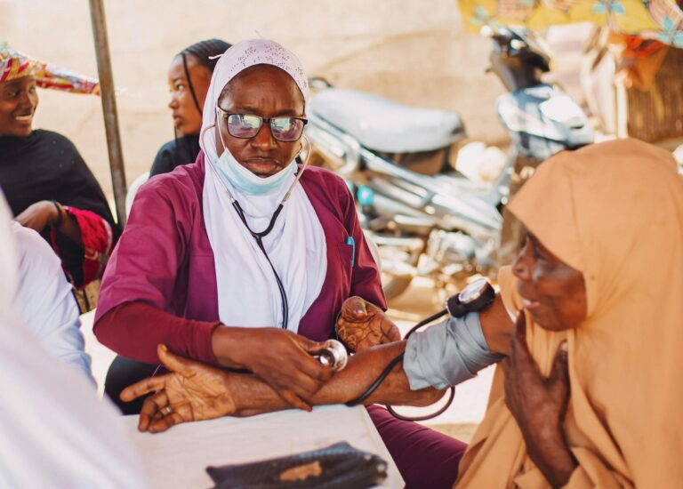 Compassion in Action: A dedicated healthcare worker provides a free medical checkup to an elderly woman, embodying the spirit of care and community.